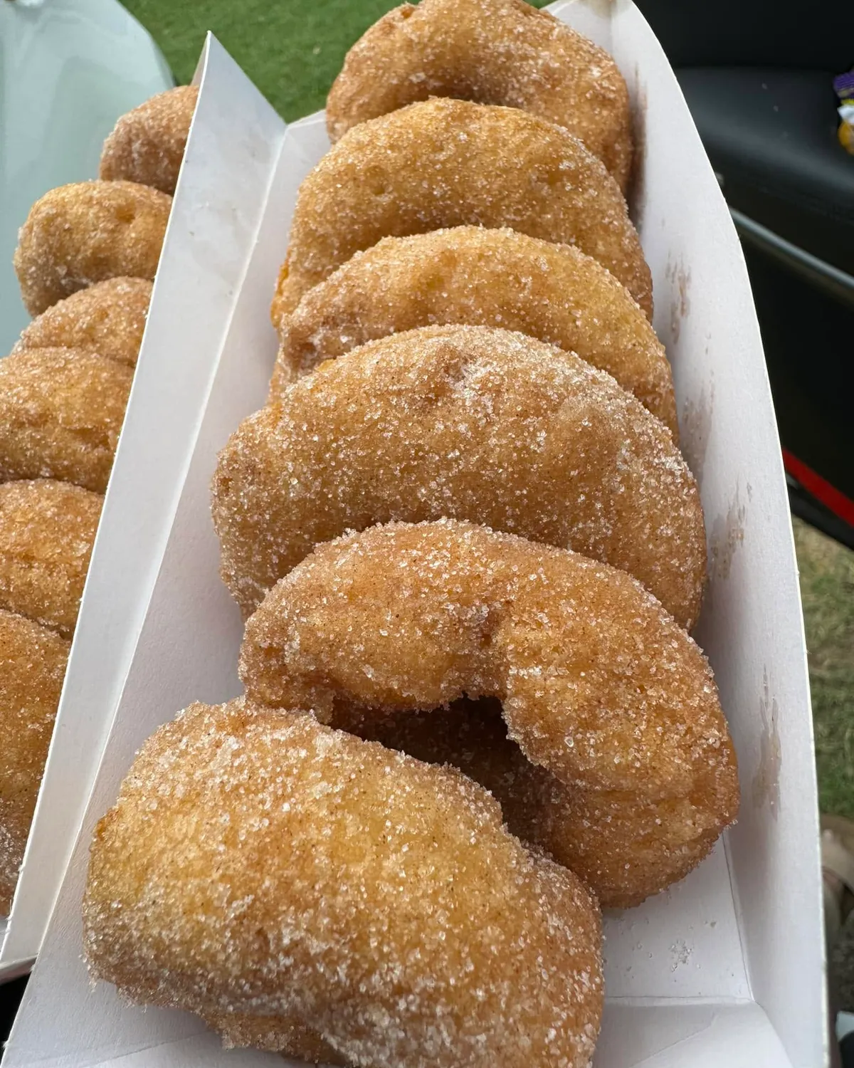 Cinnamon doughnuts stacked in a paper tray