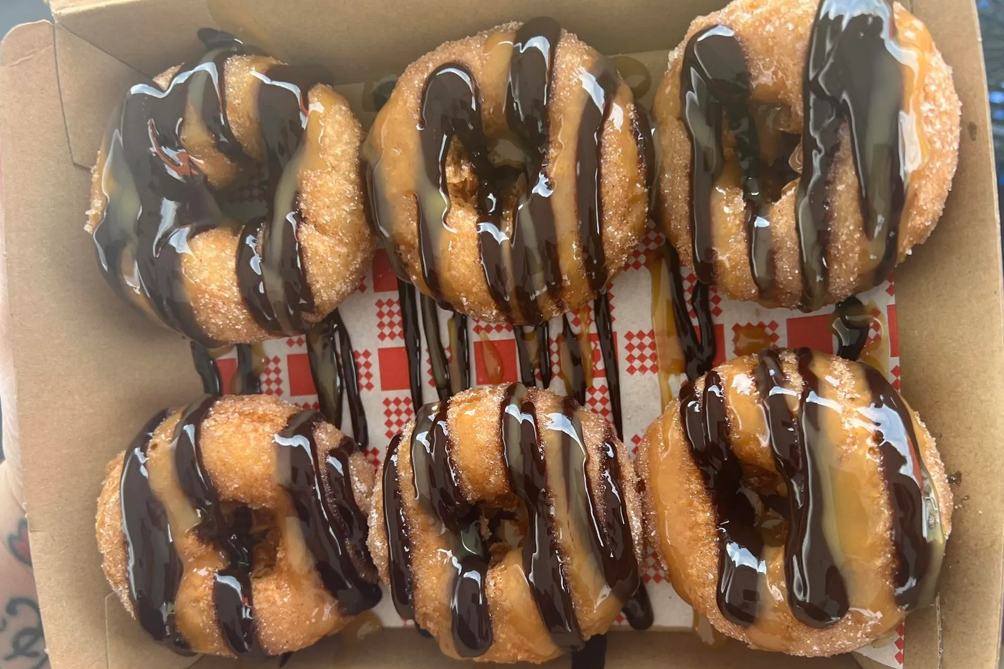 A box of chocolate drizzled gluten free doughnuts, seen from above
