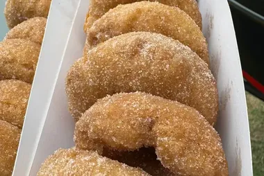 Cinnamon doughnuts stacked in a paper tray