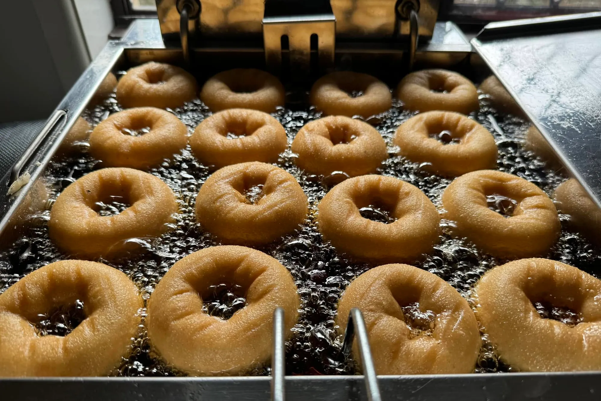 Gluten free doughnuts frying in the oil at the Devilish Doughnuts trailer