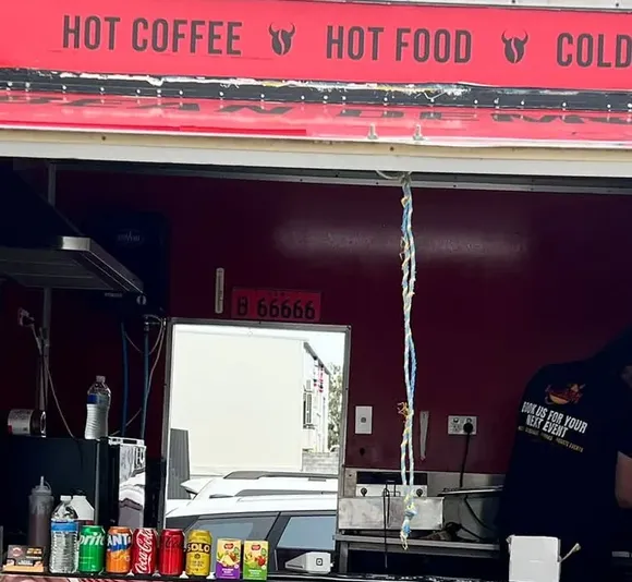 Inside the open serving hatch of the red Devilish Doughnuts trailer