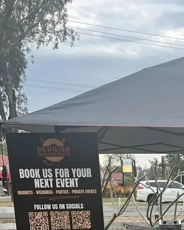 The black Devilish Doughnuts gazebo stall set up at a market