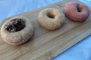 Chocolate, cinnamon and strawberry doughnuts on a wooden board